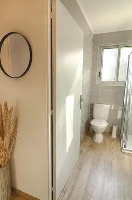 a bathroom with a toilet and a mirror at Beau studio Routes des Sanguinaires proche de la plage in Ajaccio