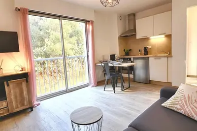 a living room with a couch and a large window at Beau studio Routes des Sanguinaires proche de la plage in Ajaccio
