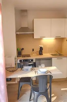 a kitchen with a table and chairs in a room at Beau studio Routes des Sanguinaires proche de la plage in Ajaccio