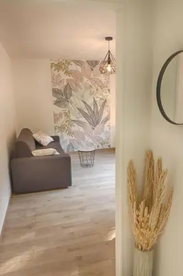 a living room with a couch and a mirror at Beau studio Routes des Sanguinaires proche de la plage in Ajaccio