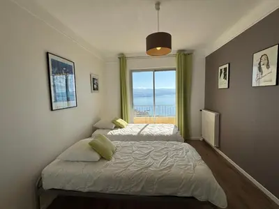 two beds in a room with a window at Appartement Parc Belvédère Ajaccio in Ajaccio