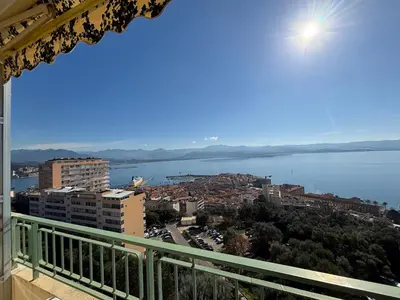a balcony with a view of a city and the water at Appartement Parc Belvédère Ajaccio in Ajaccio