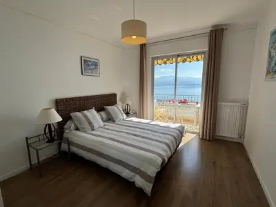 a bedroom with a large bed and a large window at Appartement Parc Belvédère Ajaccio in Ajaccio