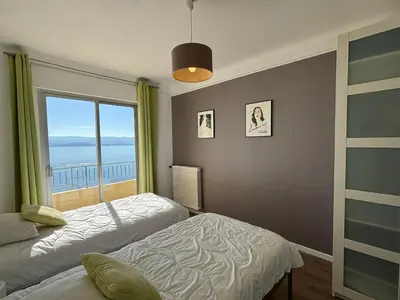 a bedroom with two beds and a large window at Appartement Parc Belvédère Ajaccio in Ajaccio