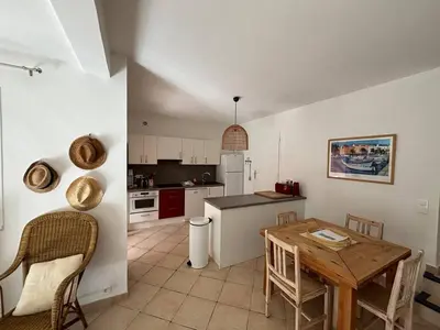 a kitchen and dining room with a table and chairs at Mini-villa à 5 minutes de la plage de Santa Giulia in Porto-Vecchio