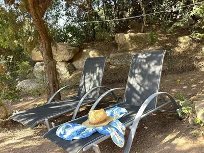 two lawn chairs with a hat sitting on them at Mini-villa à 5 minutes de la plage de Santa Giulia in Porto-Vecchio