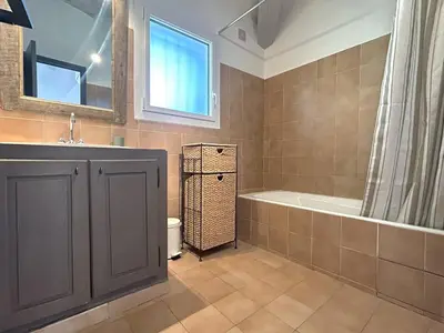 a bathroom with a tub and a sink and a bath tub at Mini-villa à 5 minutes de la plage de Santa Giulia in Porto-Vecchio