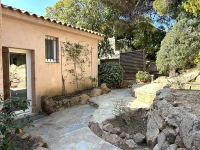 a house with a stone walkway next to a building at Mini-villa à 5 minutes de la plage de Santa Giulia in Porto-Vecchio