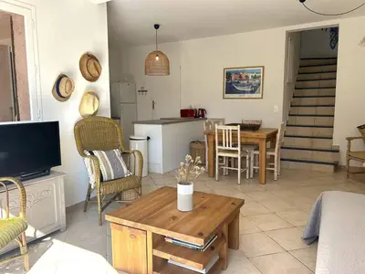 a living room with a table and a kitchen at Mini-villa à 5 minutes de la plage de Santa Giulia in Porto-Vecchio
