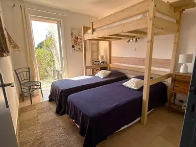 a bedroom with two beds and a large window at Mini-villa à 5 minutes de la plage de Santa Giulia in Porto-Vecchio