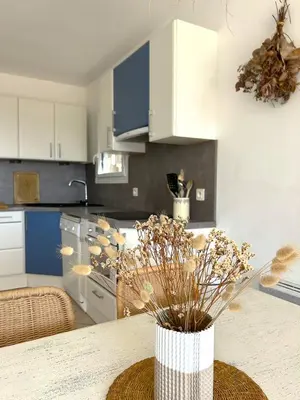 a kitchen with a table with a vase with flowers at Mini-villa à 5 minutes de la plage de Santa Giulia in Porto-Vecchio