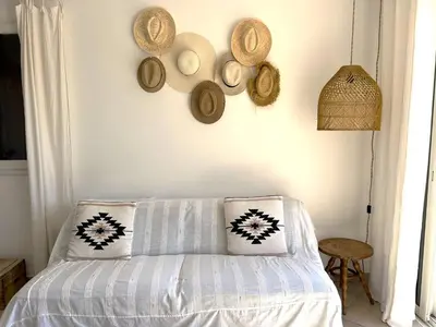 a room with a bed with hats on the wall at Mini-villa à 5 minutes de la plage de Santa Giulia in Porto-Vecchio