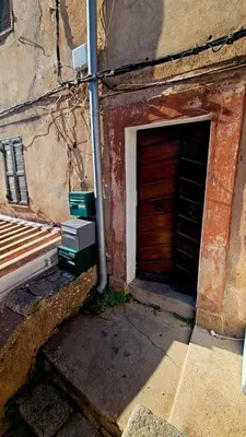 a brick building with a wooden door and a bench at Splendide T2 Piana in Piana