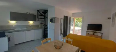 a kitchen with a table and a dining room at Porto Vecchio - Résidence RIVIERA- Villa Santa Giulia in Lecci
