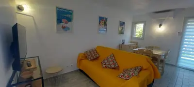 a living room with a yellow couch and a table at Porto Vecchio - Résidence RIVIERA- Villa Santa Giulia in Lecci