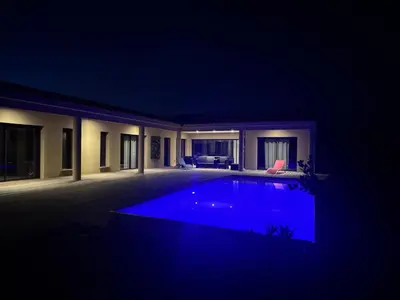 a large swimming pool in a house at night at Casa Nostra Villa Récente Climatisée - Piscine Chauffée in Lecci