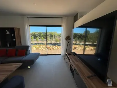 a living room with a couch and a flat screen tv at Casa Nostra Villa Récente Climatisée - Piscine Chauffée in Lecci