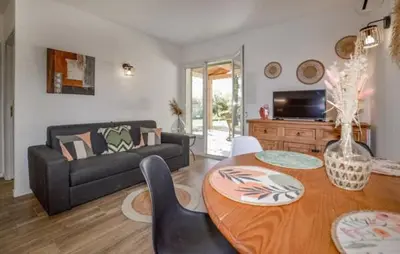 a living room with a couch and a table at Charmant T2 à la campagne in Riventosa