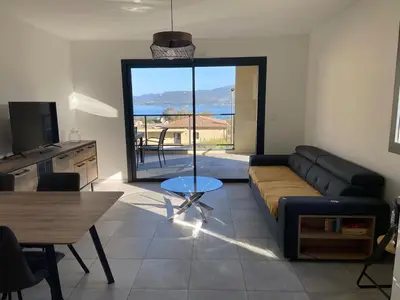 a living room with a couch and a table at Superbe T3 vue mer in Propriano