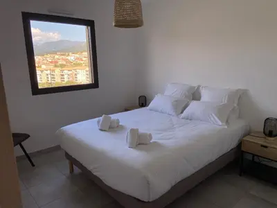a bedroom with a white bed with two towels on it at Superbe T3 vue mer in Propriano
