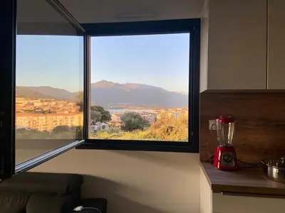 a kitchen window with a view of a city at Superbe T3 vue mer in Propriano