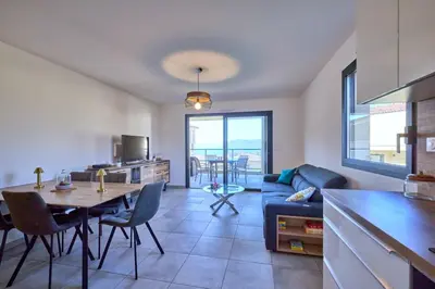 a living room with a table and a blue couch at Superbe T3 vue mer in Propriano