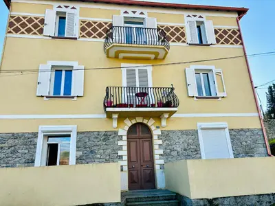 a yellow building with windows and a door and balcony at Casa Straboni Corte in Corte