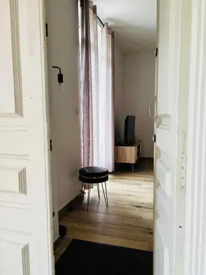 a hallway with a table and a stool in a room at Casa Straboni Corte in Corte