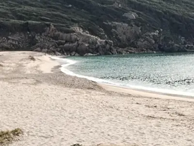 a beach with a body of water and a mountain at Villa individuelle avec jardin in Sartène