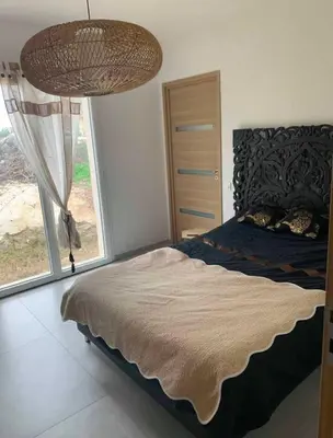 a bedroom with a bed and a large window at Villa ALMA in Porto-Vecchio