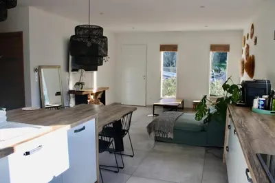 a kitchen and living room with a table and a couch at Villa ALMA in Porto-Vecchio