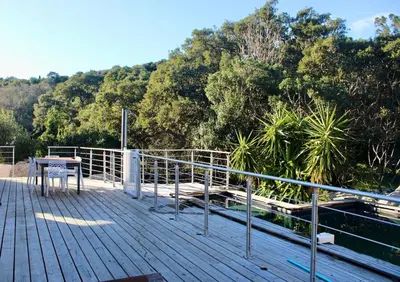 a wooden deck with a table and a fence at Villa ALMA in Porto-Vecchio