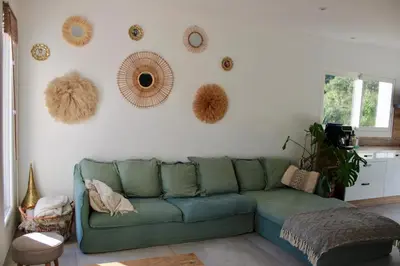 a living room with a green couch and some mirrors at Villa ALMA in Porto-Vecchio
