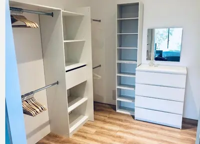 a walk in closet with white cabinets and drawers at MaisonDrs in Porto-Vecchio