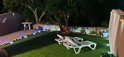 two white chairs sitting on a lawn at night at Porto Vecchio - Résidence RIVIERA - Villa Pinarello in Lecci