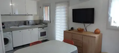 a kitchen with a sink and a tv on the wall at Porto Vecchio - Résidence RIVIERA - Villa Pinarello in Lecci