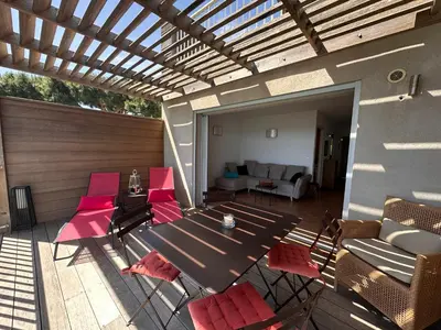 a patio with a table and chairs and a couch at Les oliviers 11 Appartement, bord de mer, porto-vecchio in Porto-Vecchio