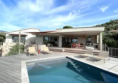 a house with a swimming pool in front of a house at Villa Cazélie, piscine vue splendide sur le Golfe in Porto-Vecchio