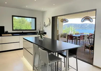 a kitchen and dining room with a table and chairs at Villa Cazélie, piscine vue splendide sur le Golfe in Porto-Vecchio