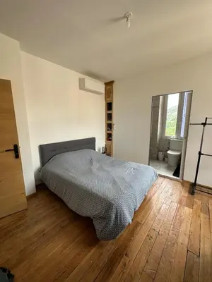a bedroom with a bed and a bathroom with a toilet at Superbe appartement en centre ville in Corte