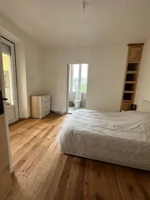 a bedroom with a bed and a wooden floor at Superbe appartement en centre ville in Corte