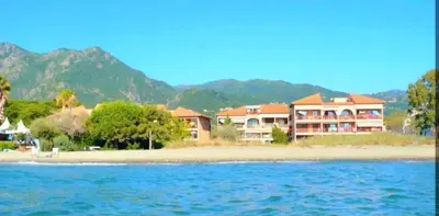 a resort on a beach with mountains in the background at Studio accueillant à San-Nicolao avec vue mer, 27 m² in San-Nicolao