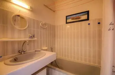 a white bathroom with a sink and a bath tub at Studio accueillant à San-Nicolao avec vue mer, 27 m² in San-Nicolao