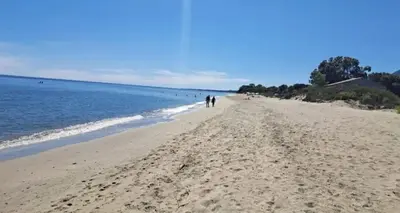 two people walking on a beach near the water at Studio accueillant à San-Nicolao avec vue mer, 27 m² in San-Nicolao