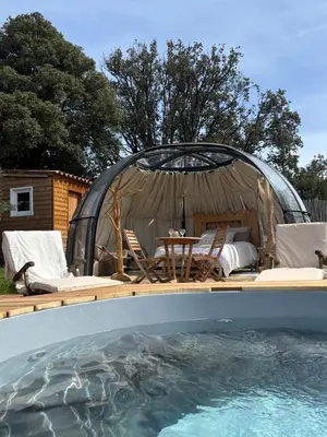 a gazebo with chairs and a table next to a swimming pool at Dôme étoilé in Vallica