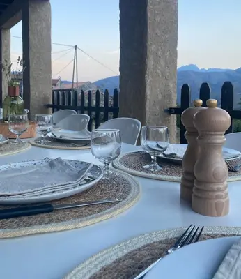 a white table with plates and wine glasses on it at Dôme étoilé in Vallica