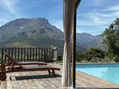 a wooden deck with a bench next to a swimming pool at Dôme étoilé in Vallica