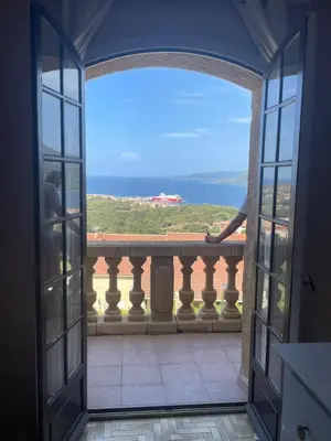 an open door to a balcony with a view of the ocean at Villa Propriano vue mer in Viggianello