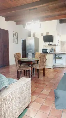 a living room with a table and chairs and a kitchen at 1st floor apartment in 18th century character house in Calvi