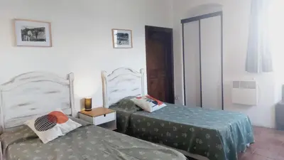 a bedroom with two beds and a night stand with a lamp at 1st floor apartment in 18th century character house in Calvi